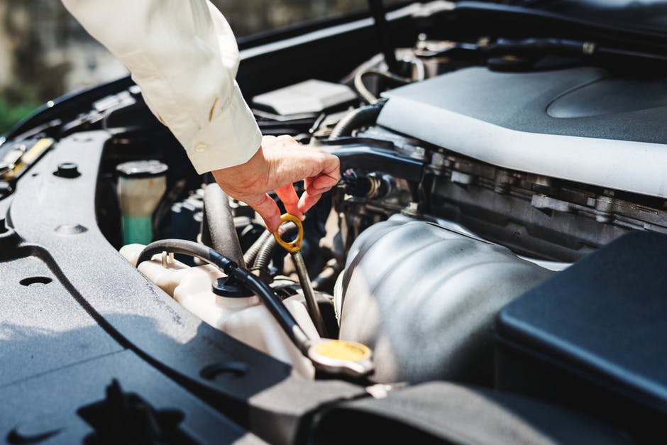 person checking fluids in car