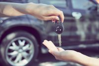 person handing over car key