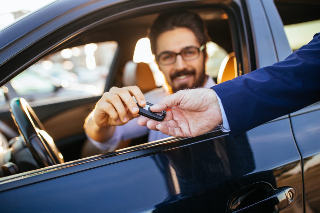 person handing key to driver