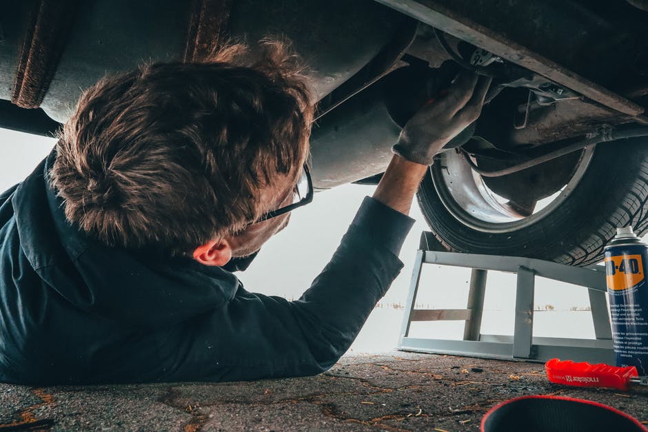 car repair man working under vehicle